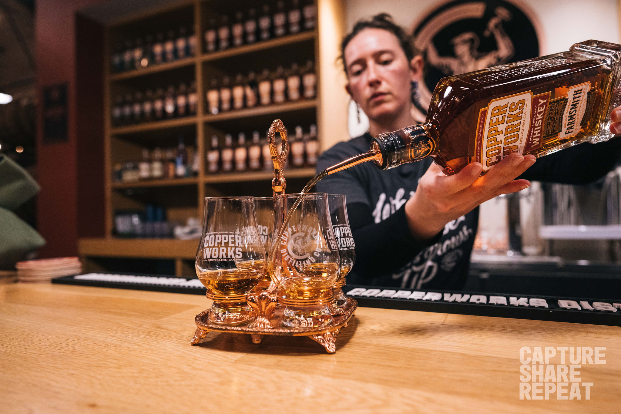 Bartending pouring whiskey for a tasting flight.