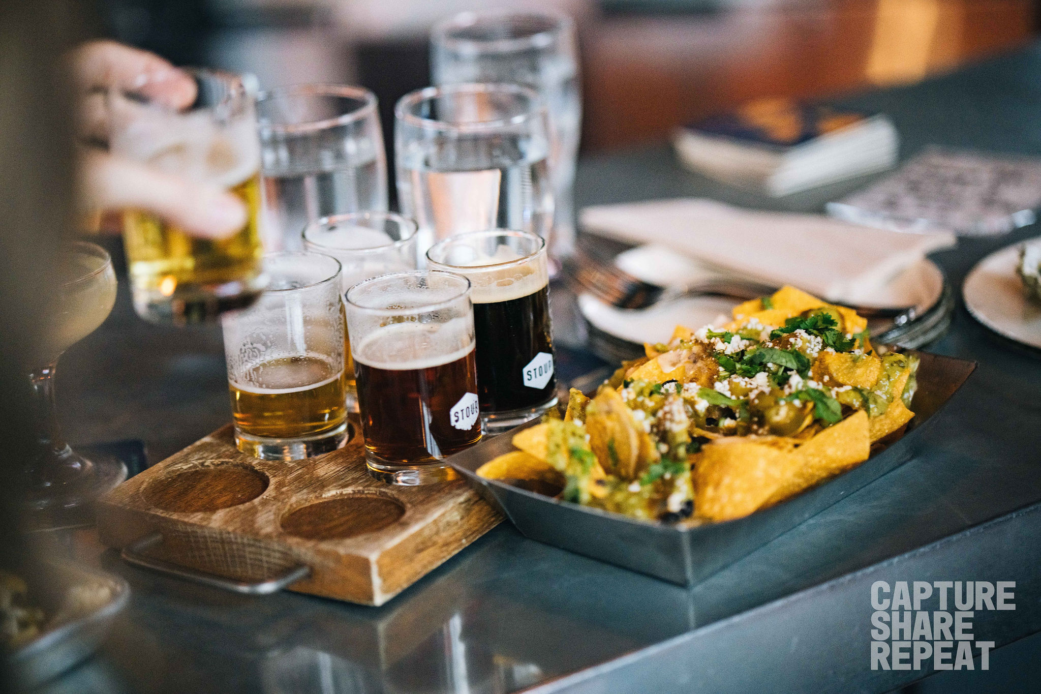 Beer flight and nachos on display at a restaurant.