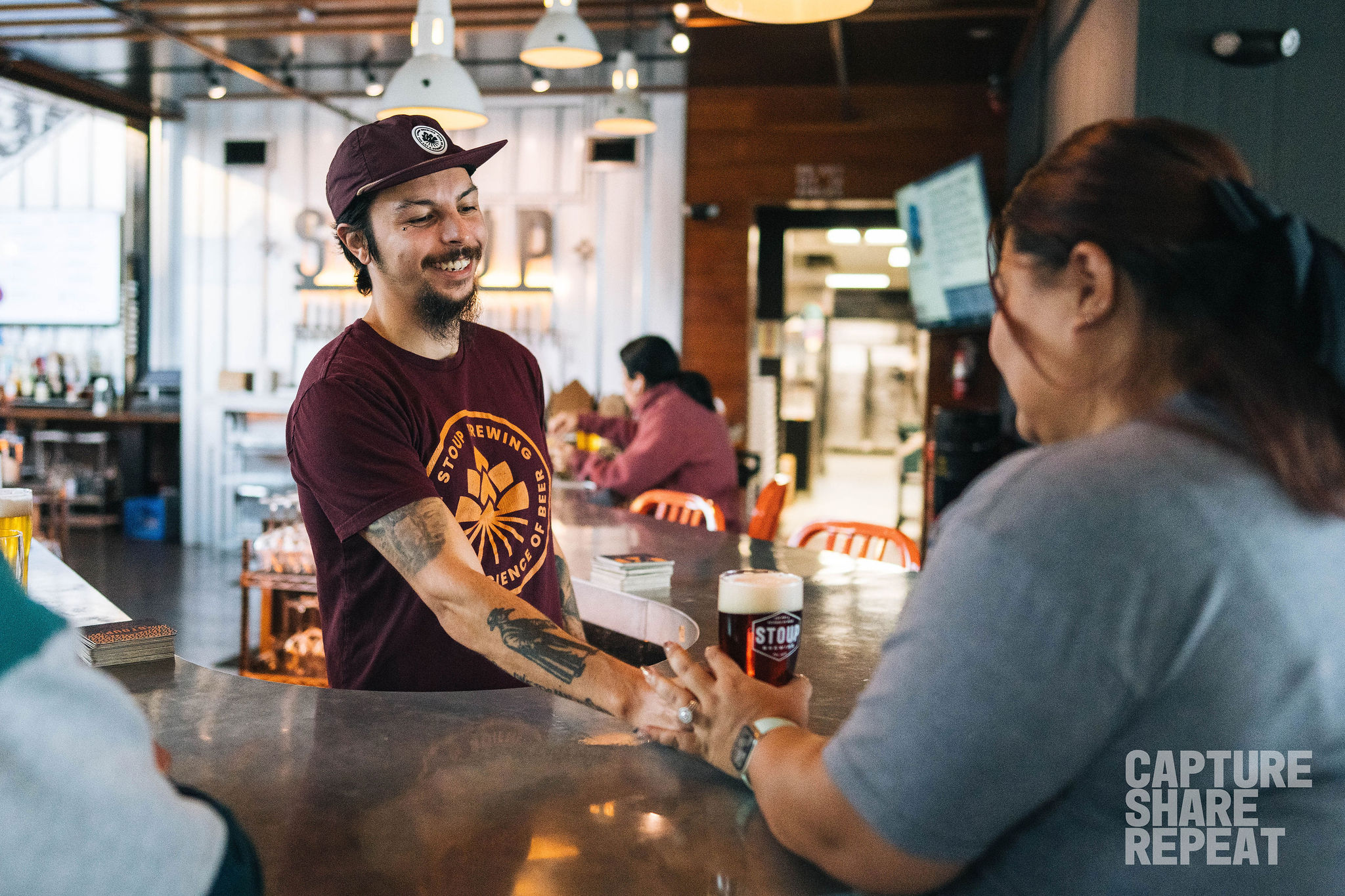 Bartender serving a beer to a customer at a bar/restaurant.