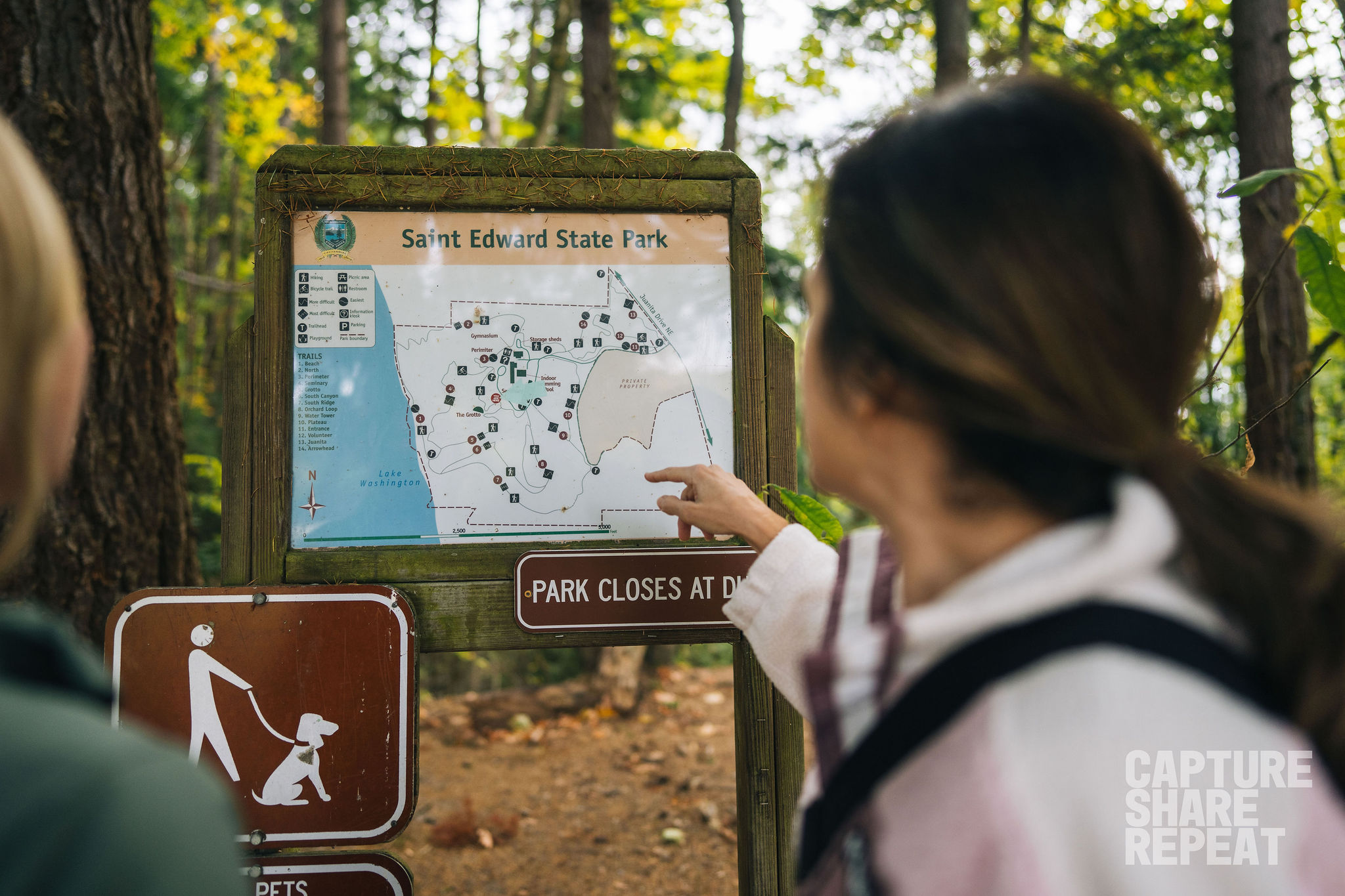 Two women hikers looking at and navigating the trail map at Saint Edward State Park.